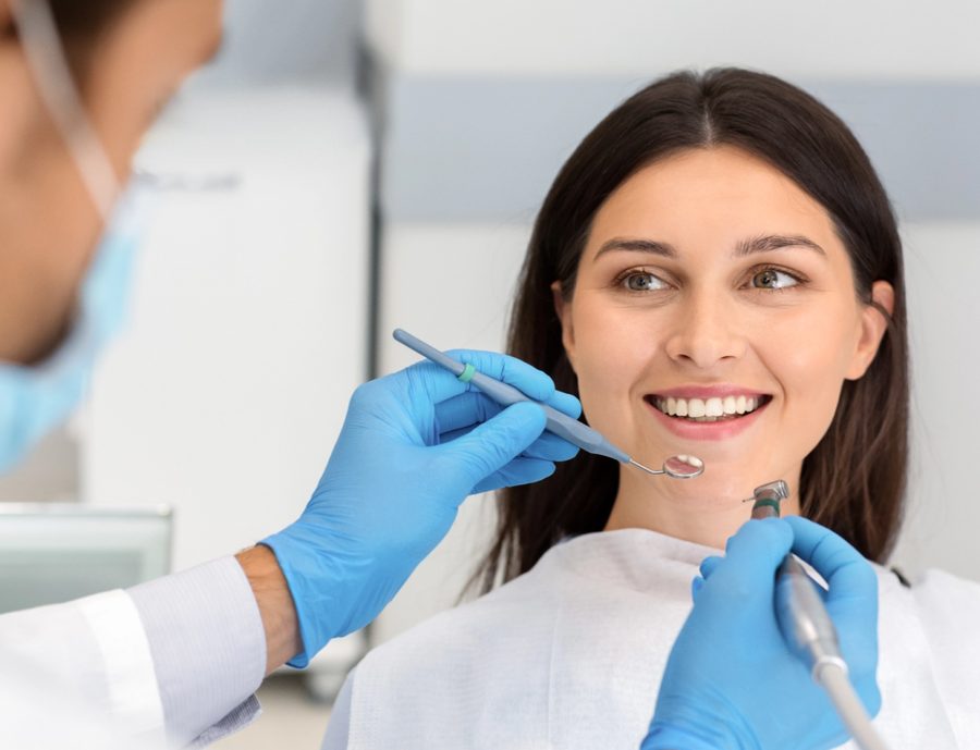Dentista examinando o sorriso de uma paciente na Clínic Multi Espaço